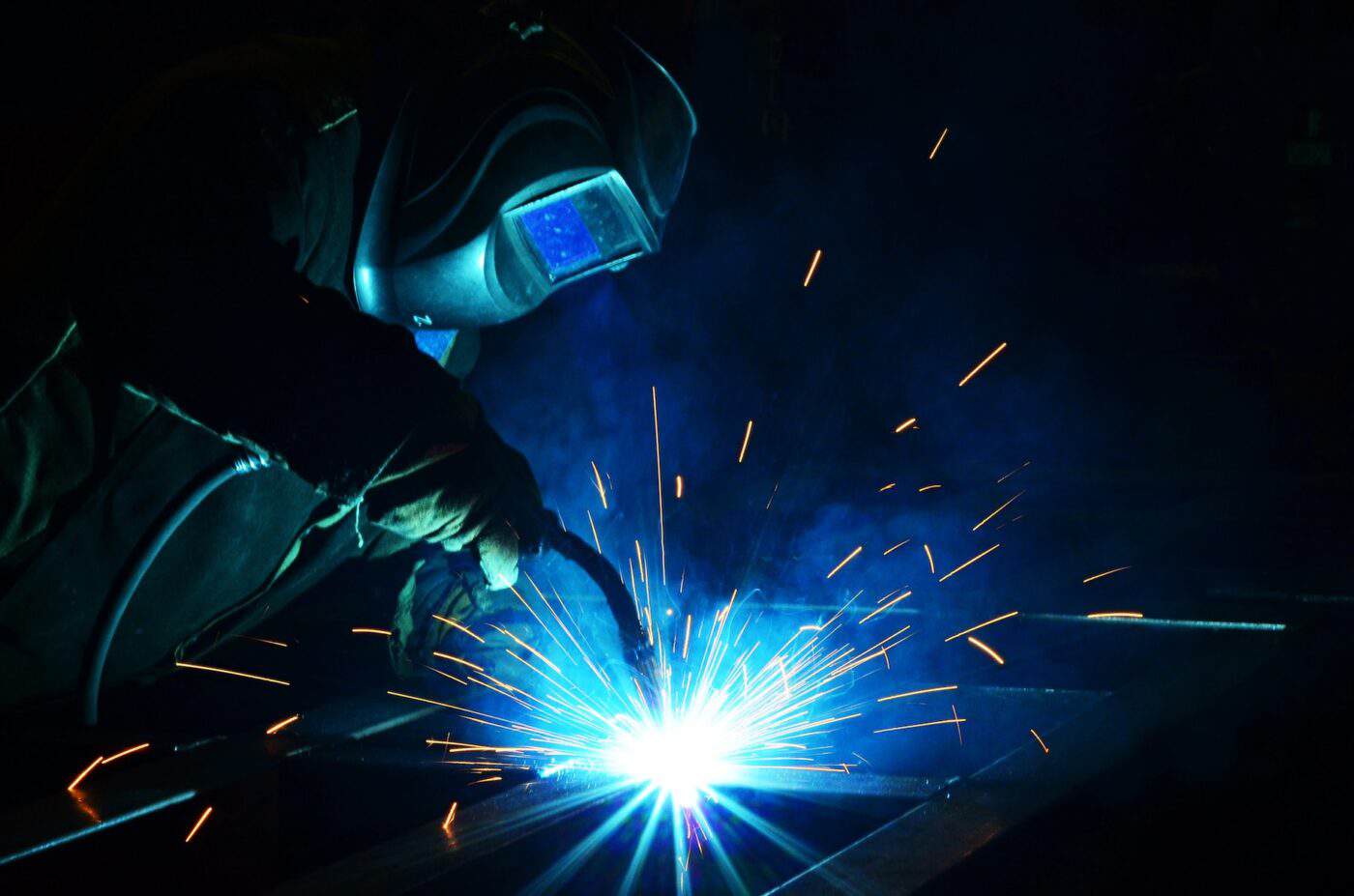 A welder is using a tool to weld metal